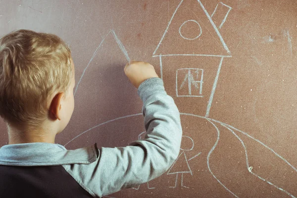 Little boy draws with chalk on a blackboard, — Stock Photo, Image