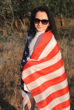 Kız açık havada Amerikan bayrağı ile yıldızlar ve çizgiler flutters Rüzgardaki bayrak,