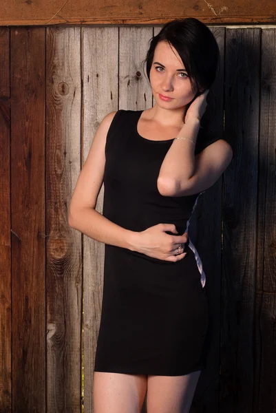 Schönes Mädchen im Abendkleid, das Model posiert vor einer Holzwand, — Stockfoto