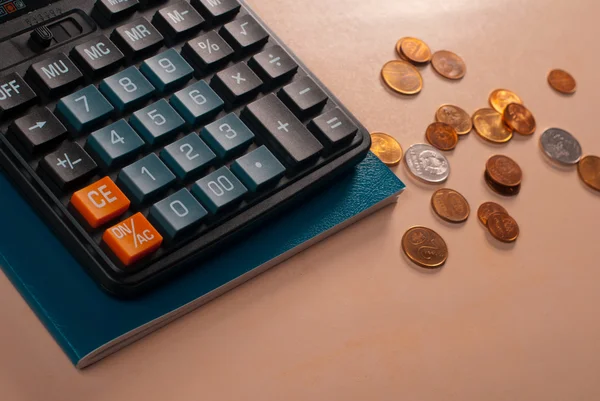 Geldkonzept. Taschenrechner mit Münzen liegen auf dem Schreibtisch, — Stockfoto