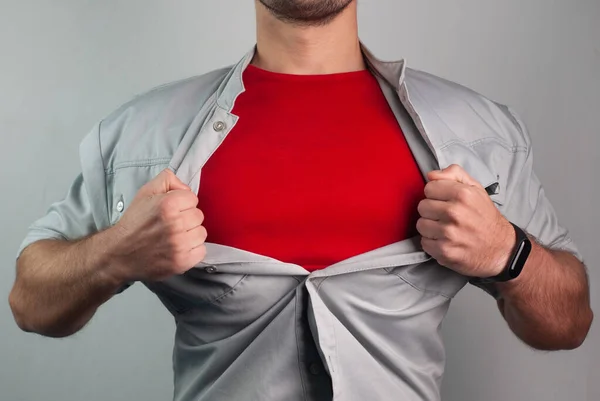 Super man in red rips the shirt on his chest