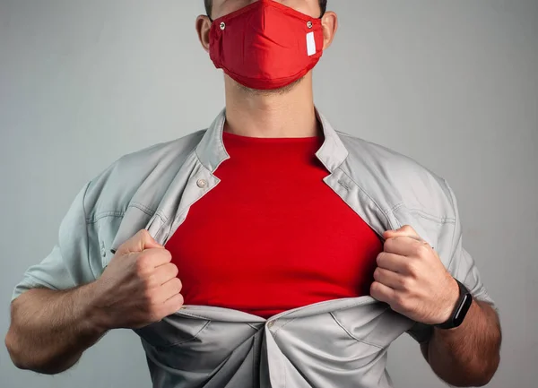 Super-herói em uma máscara médica rasga a camisa em seu peito — Fotografia de Stock