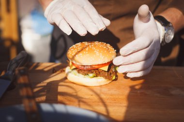 Şef bir hamburger bir kara tahta üzerinde hazırlar