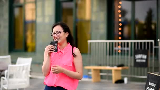 Hermosa, chica atractiva bebiendo café en una calle de la ciudad — Vídeos de Stock