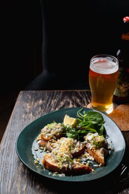 Hafif bira, kızarmış ekmekler, koyu ahşap bir masada, bir barda.