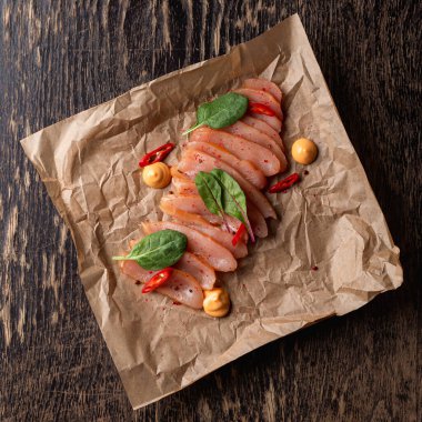 Lüks bir barda gurme aperatifi: yumuşak hardallı dilimlenmiş tavuk göğsü ve kırmızı biber taneleri.