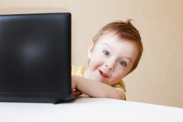 neşeli çocuk peeks dışarı onun laptop arkasından