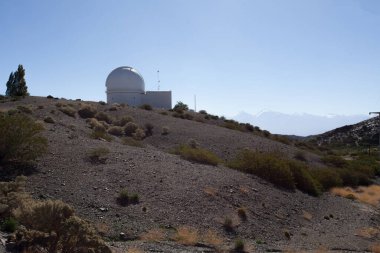 Arka planda ay olan astronomik gözlemevinin dramatik görüntüsü