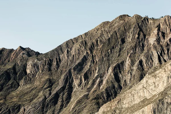 Bulutsuz bir gökyüzüne karşı güzel görkemli bir dağ. Taş yüzeyin katları ve dalgaları