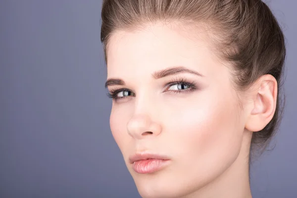 Närbild porträtt av ung kvinna på grå bakgrund. Naken makeup — Stockfoto