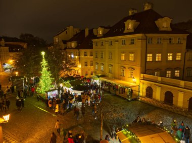 Prag 'ın tarihi meydanında süslü ağaçlarla aydınlatılmış Noel pazarının gece manzarası