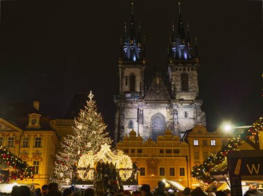 Prag, Çek Cumhuriyeti - 13 Aralık 2024: Prag Eski Şehir Meydanı 'nda Tyn' den önce aydınlatılmış Noel ağacı ve kilisemiz