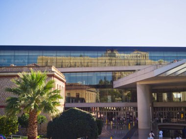 Atina, Yunanistan - 25 Ekim 2025: Cam dış görünüşlü çağdaş yeni Akropol müzesi ve Parthenon 'u yansıtan basamaklarda ziyaretçiler