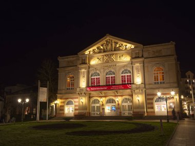Klasik mimarisi olan tarihi Baden-Baden tiyatro binası karanlık gece gökyüzüne karşı güzelce aydınlatılmış.