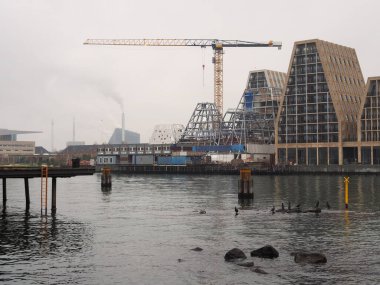 Kopenhag, Danimarka 'da deniz kenarı boyunca inşa edilen vinç ve modern binalar.