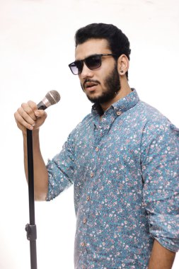 Gözlük takan ve bir şarkı söylerken mikrofon tutan genç erkekler