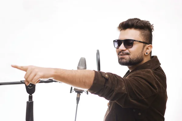 Hombres con abrigo marrón y gafas cantando en microp condensador — Foto de Stock