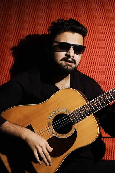 Beau jeune musicien jouant de la guitare et chantant — Photo