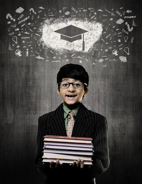 Gorra de graduación. Genius Boy sosteniendo libros con gafas, tiza —  Fotos de Stock