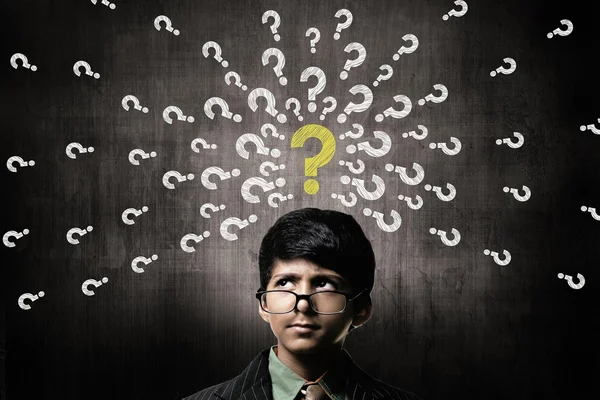 Menino confuso vestindo óculos, pensando perto Chalkboard — Fotografia de Stock