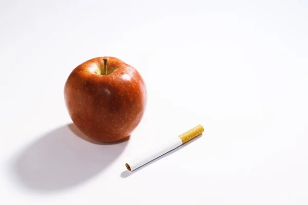 Modo de vida saludable. Manzana roja y cigarrillo — Foto de Stock