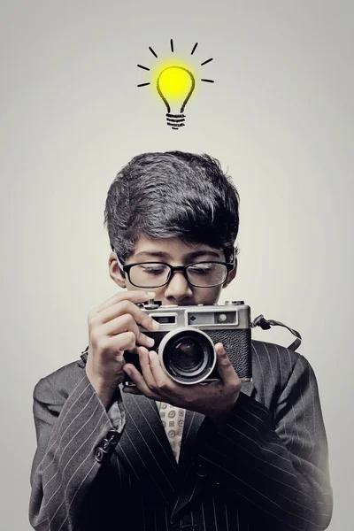 Fotógrafo infantil segurando uma câmera - Lâmpada de ideias — Fotografia de Stock