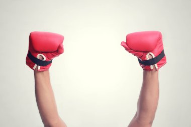 Two hands raised in the air wearing boxing gloves clipart