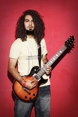 Güzel uzun kıvırcık saçlı genç gitarist adam