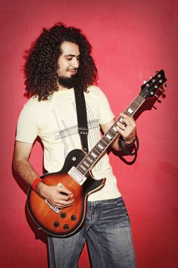 Tutkulu gitarist güzel uzun kıvırcık saç playin ile mutlu