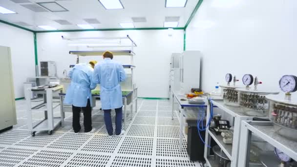 Se recogieron dos ingenieros y se probaron partes de los instrumentos de dispositivos de prueba de laboratorio de tecnología de dispositivos — Vídeo de stock