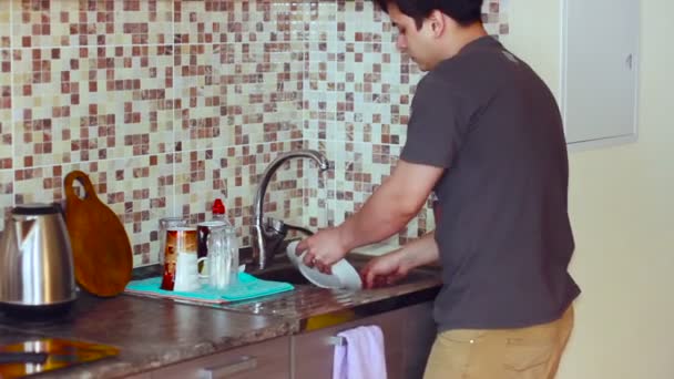 In de keuken Man was zinken de platen in T-Shirt — Stockvideo