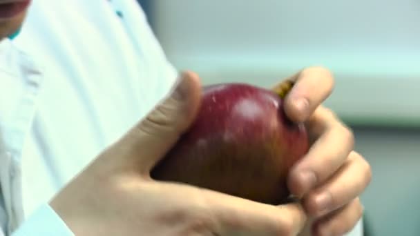 Ο άνθρωπος σε ένα άσπρο παλτό κάνει το γεύμα μάνγκο ελέγχους εξέταση στο εργαστήριο ελέγχου τροφίμων — Αρχείο Βίντεο