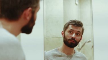 Ayna arkasında sakallı yakışıklı adam