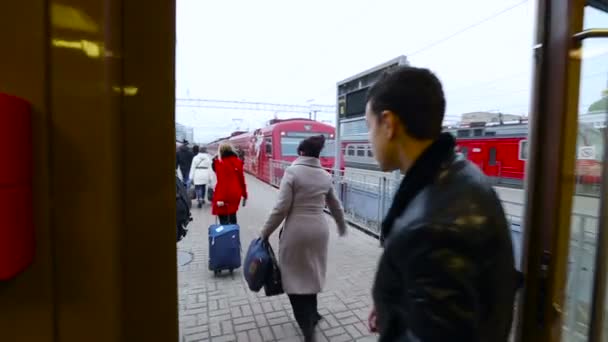 荷物を持つ人々 プラットフォーム赤鉄道鉄道の日冬秋春ロシアの電車に乗る — ストック動画