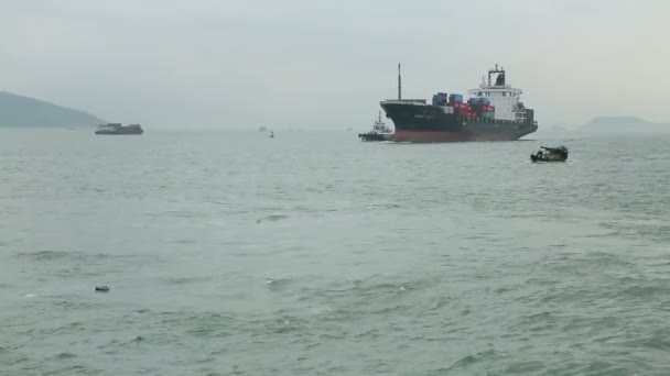 Vista do navio chinês no mar transporta mercadorias contra o pano de fundo de pequenos barcos — Vídeo de Stock