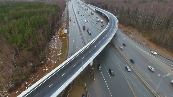 Autopista con cruce de carreteras Día del tráfico de coches Puente de otoño, Vista aérea. Con el bosque — Vídeos de Stock