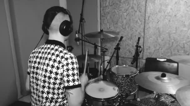 Young Drummer in a Headphones in the Studio at the Back. Grabación de sonido. Music Band. Blanco y negro. Mid Shot — Vídeos de Stock