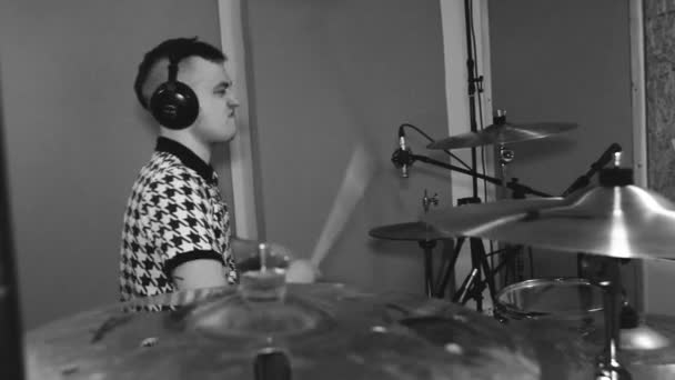 Joven baterista con auriculares en el estudio. Grabación de sonido. Metal. Blanco y negro. Mid Shot — Vídeo de stock
