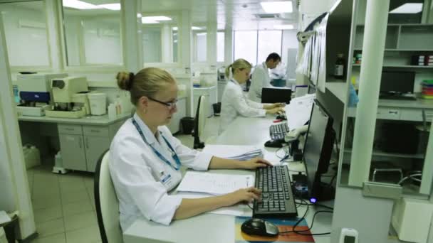 Mujer escribiendo rápido en la computadora del laboratorio médico — Vídeo de stock