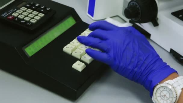 Επιστήμονας στα λαστιχένια γάντια καταγράφει τα δεδομένα για την έρευνα στο ιατρικό εργαστήριο, κοντινό πλάνο — Αρχείο Βίντεο