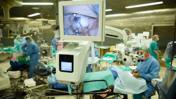 眼科。大型手术室。医生进行眼科手术。显示屏上的宏观图像的眼睛 — 图库视频影像