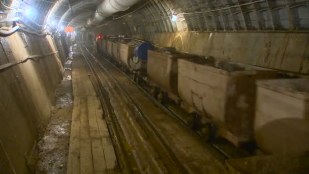 岩とトロリーのトンネルを通って乗り物。地下鉄トンネルの地下工事 — ストック動画