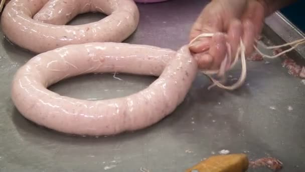 Lavoratore nella produzione di carne. Legare la salsiccia in produzione — Video Stock