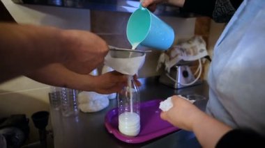 Çiftlik. Şişelere süt dökmek. İnsanlar sütü şişelere döker