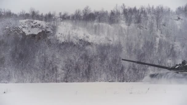 Сніговий покрив полігону стрільби в високогір'ї. Танк їде на полі з високою швидкістю — стокове відео