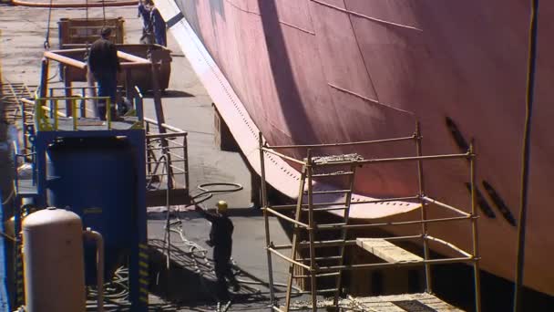Οι άνθρωποι δουλεύουν στο λιμάνι. Ένα μεγάλο πλοίο είναι στο λιμάνι κατά τη διάρκεια της θερμής περιόδου. 04.06.2009 — Αρχείο Βίντεο