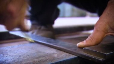 Bir adam elinde keskin metal bir alet tutar. Daha fazla kesinti için ürünler. - Rusya. 02.03.2010