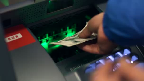 ATM serviço de caixa automático. O homem põe dinheiro na caixa de dinheiro da máquina. Vista de perto — Vídeo de Stock