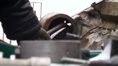 Eldivenli bir adam sokakta levyeyle çalışıyor. Metal aygıt