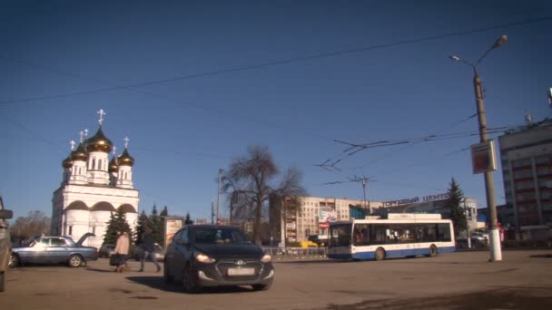 Міські трамваї на дорозі. Церква та інші будівлі на вулиці в місті. — стокове відео
